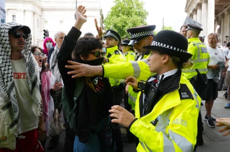 Police officers and protesters during a demonstration at Trafalgar Square in London to support Palestine Action, 23 June.
