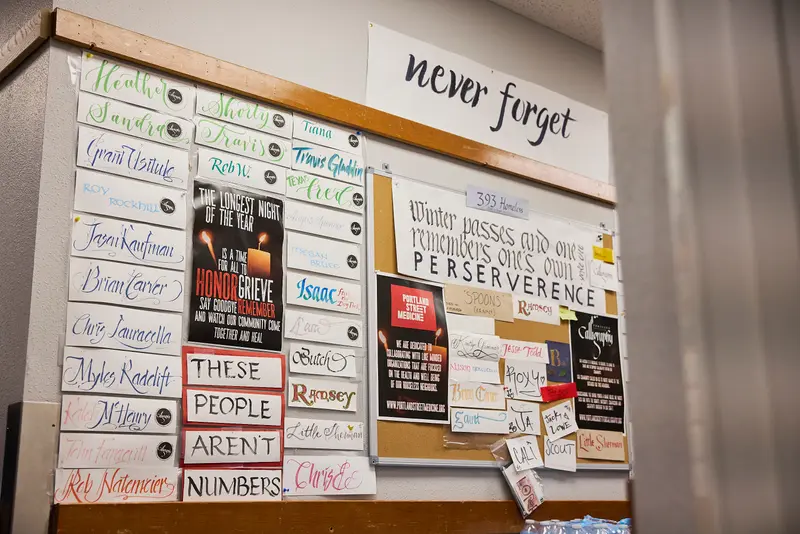 A wall with posters with names of the dead and text including: “These people aren’t numbers,” “never forget,” and “Winter passes and one remembers one’s own perseverance.”