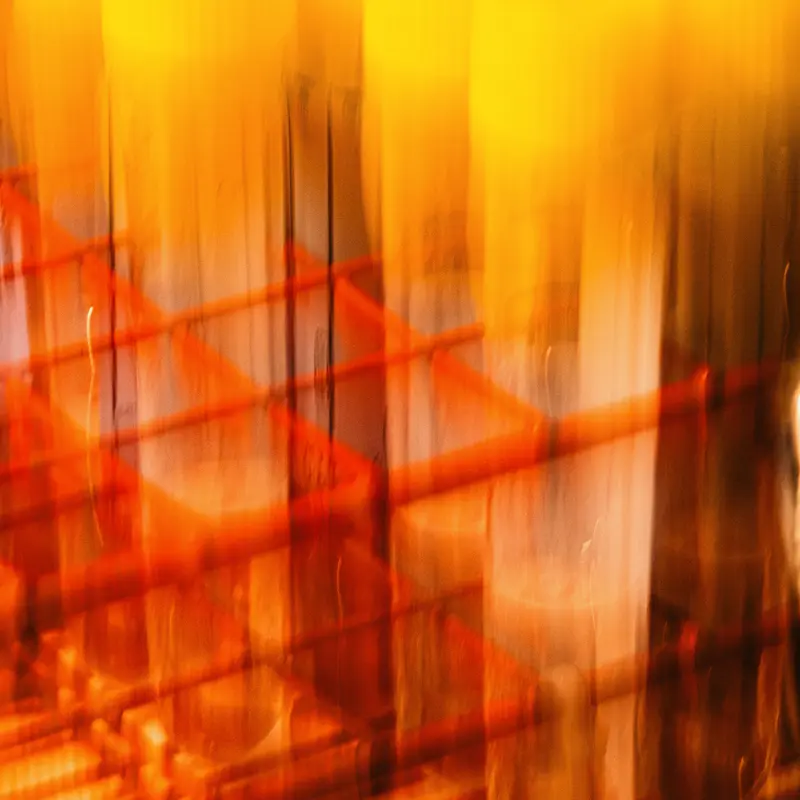 Close up of blurry yellow and orange tubes for blood samples in a red rack.