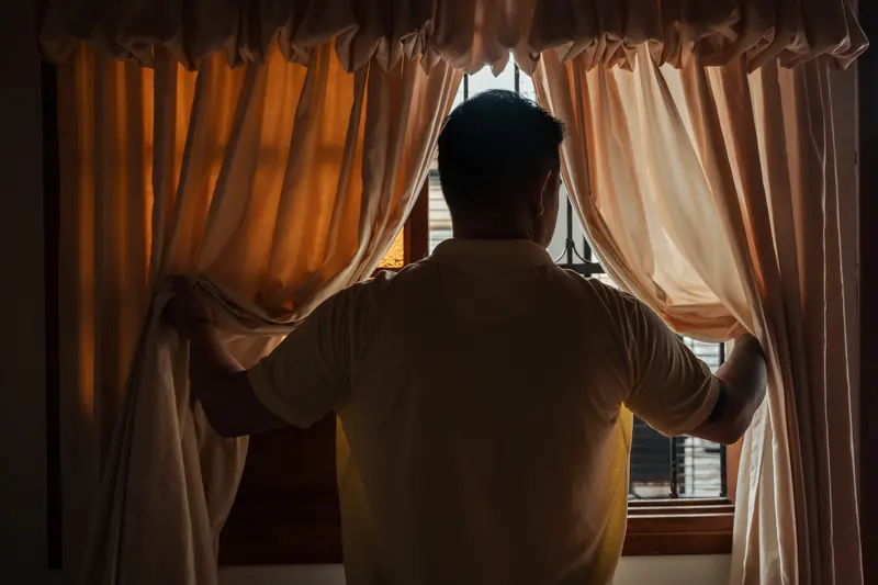 Andry Omar Blanco Bonilla looks out the window at his house.