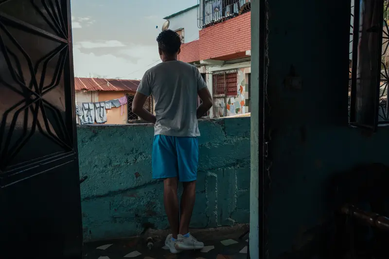 Juan José Ramos Ramos looks out from a balcony at his house.