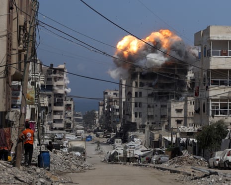 Smoke and flames rise from a residential building hit by an Israeli strike, in Gaza City on 21 July 2025.