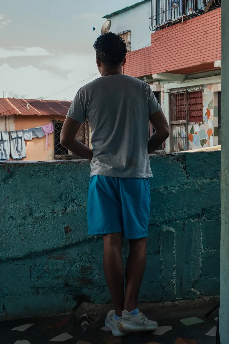 Juan José Ramos Ramos looks out from a balcony at his house.