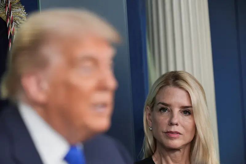 U.S. Attorney General Pam Bondi looks at President Donald Trump while he speaks.