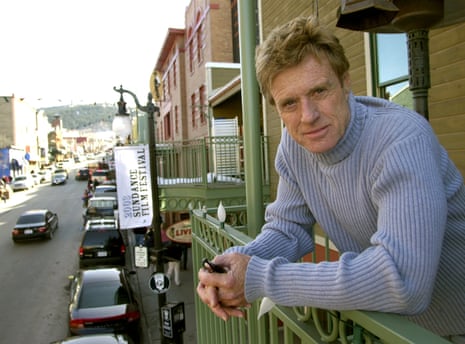 Robert Redford poses on a balcony along Main Street decorated with his Sundance Film Festival banners in 2003