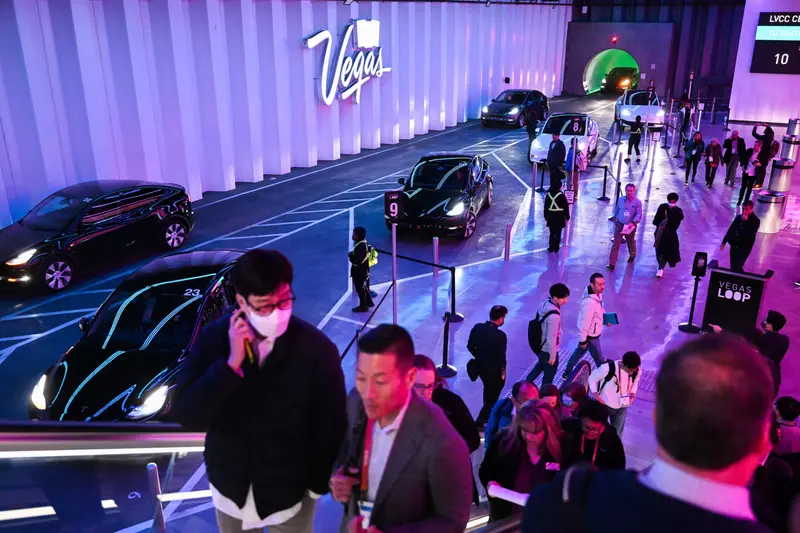 People ride escalators and line up inside the Boring Co.’s Las Vegas Convention Center Loop Station.