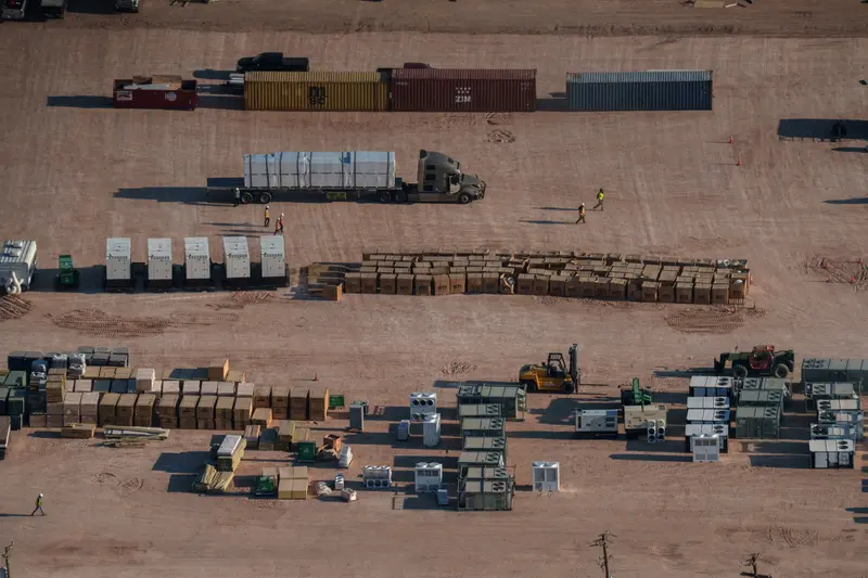 An aerial photograph shows construction workers and equipment.