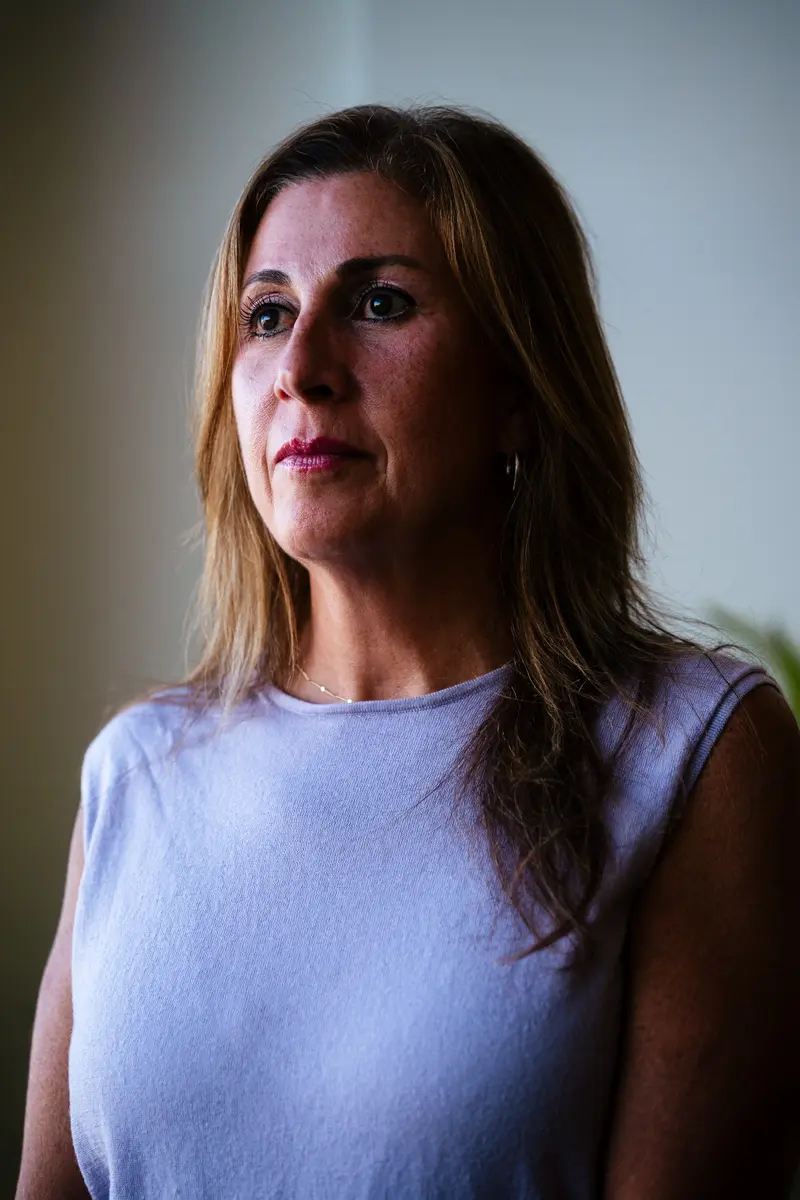 Dr. Randa Jundi-Samman poses for a portrait against a white wall.