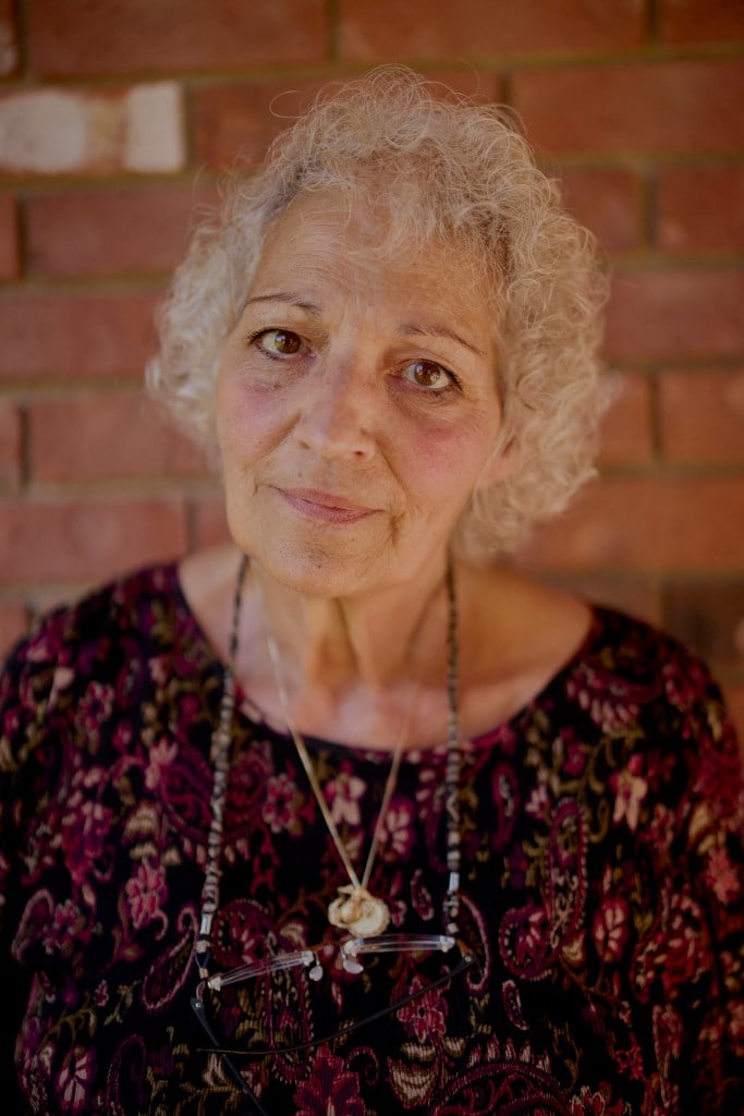 Cindy Meckel, a woman with white curly hair, gazes into the camera.