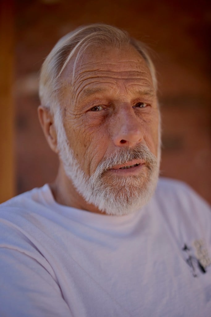 David Meckel, a white-haired bearded man. looks seriously into the camera.