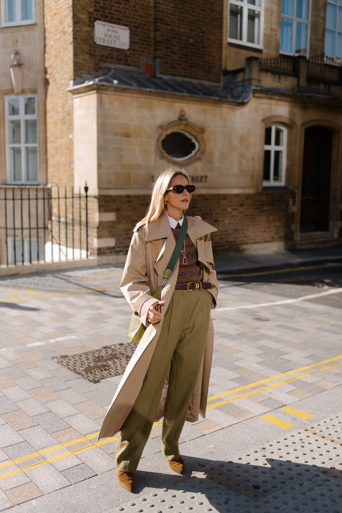 Trench marron clair, pull marron et pantalon en soie vert