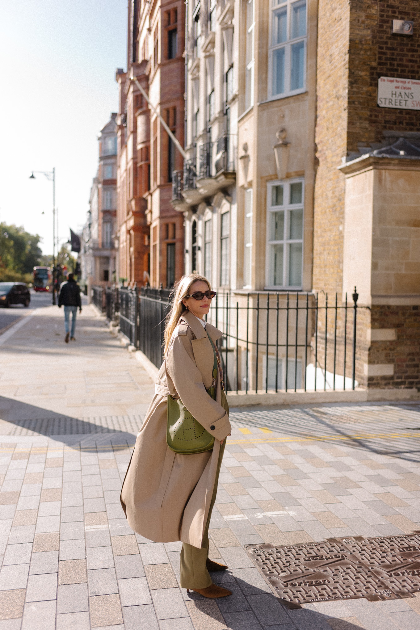 Trench marron clair, pull marron et pantalon en soie vert