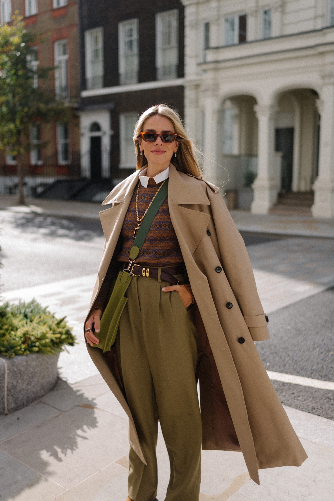Trench marron clair, pull marron et pantalon en soie vert