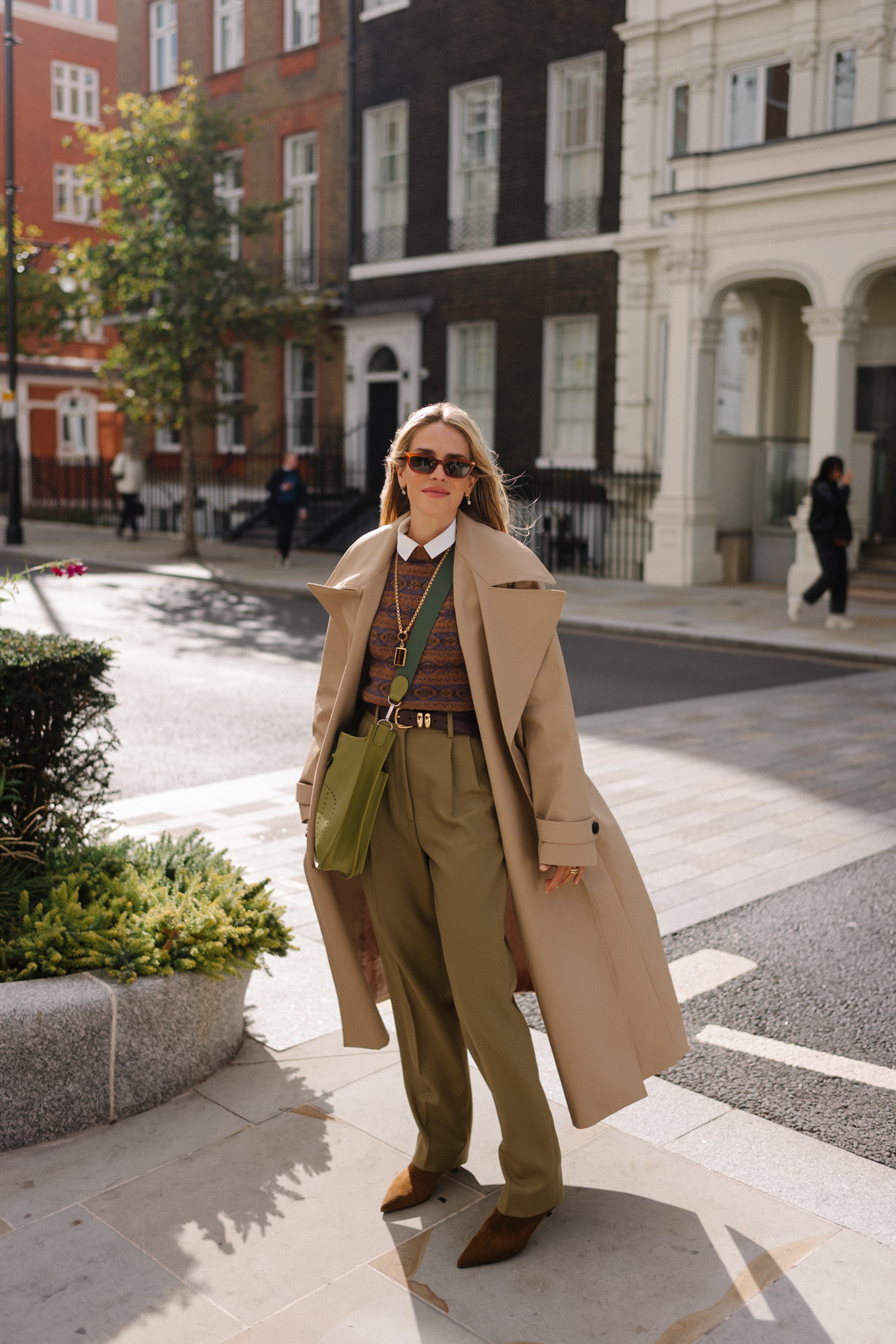 Trench marron clair, pull marron et pantalon en soie vert