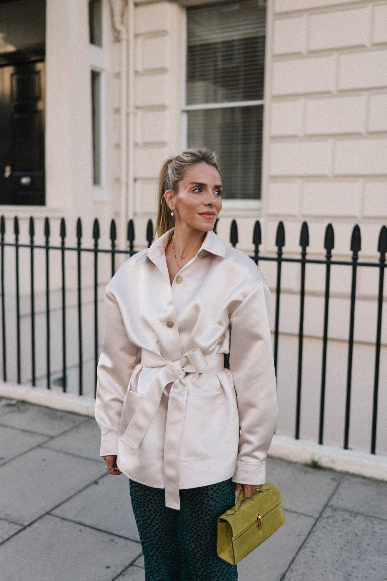 Veste blazer en satin, pantalon en velours vert, escarpins roses, sac à main chartreuse