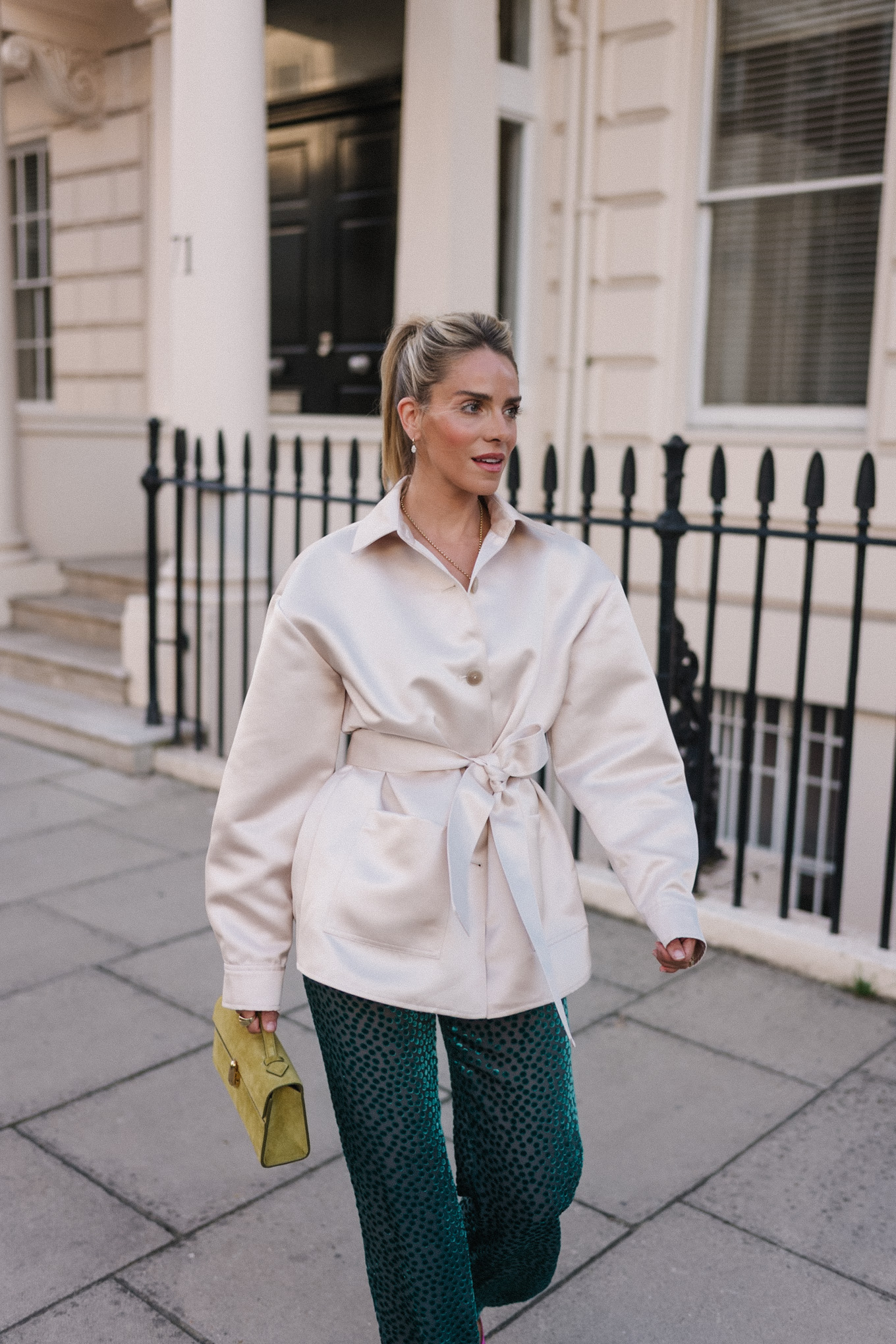 Veste blazer en satin, pantalon en velours vert, escarpins roses, sac à main chartreuse