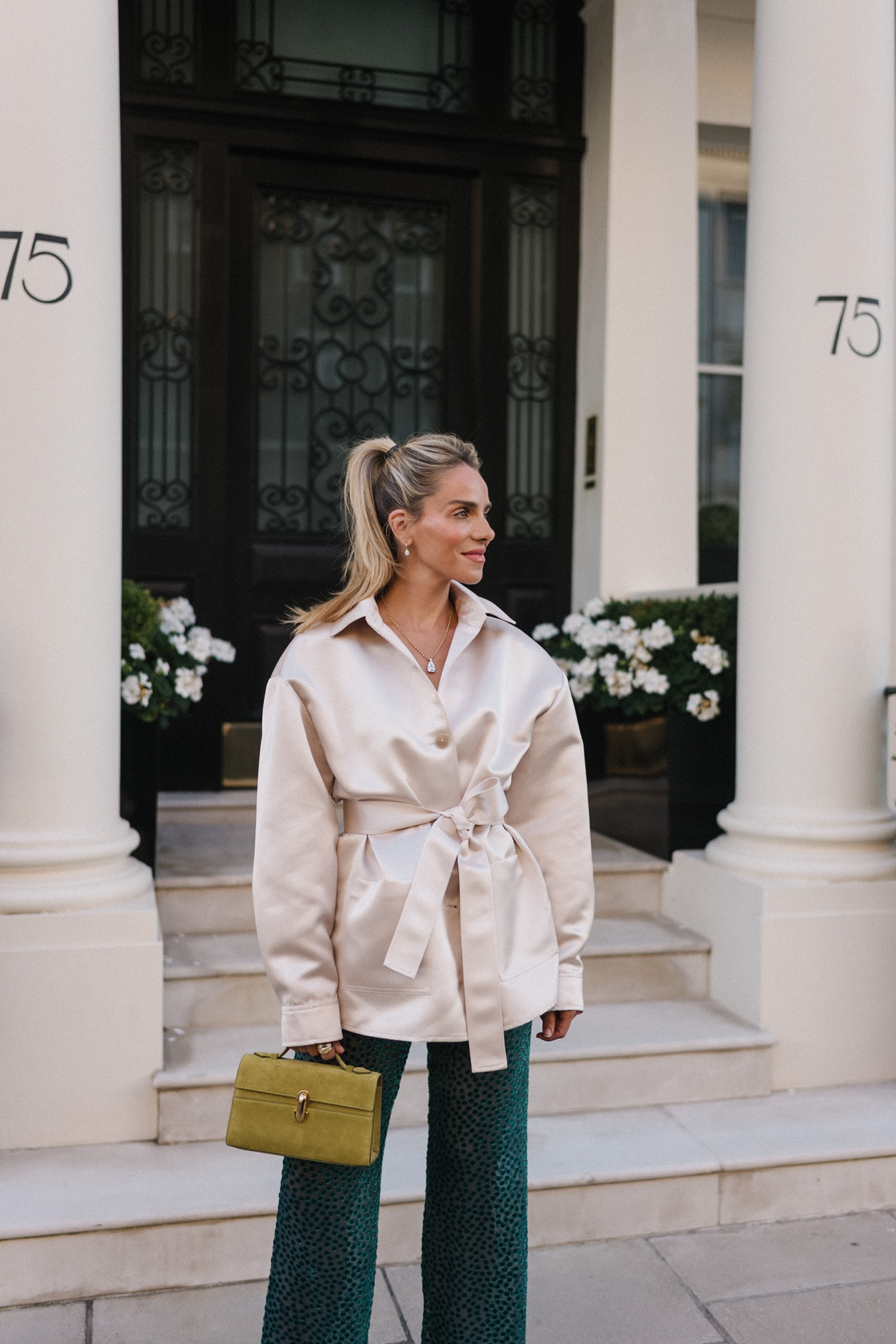 Veste blazer en satin, pantalon en velours vert, escarpins roses, sac à main chartreuse