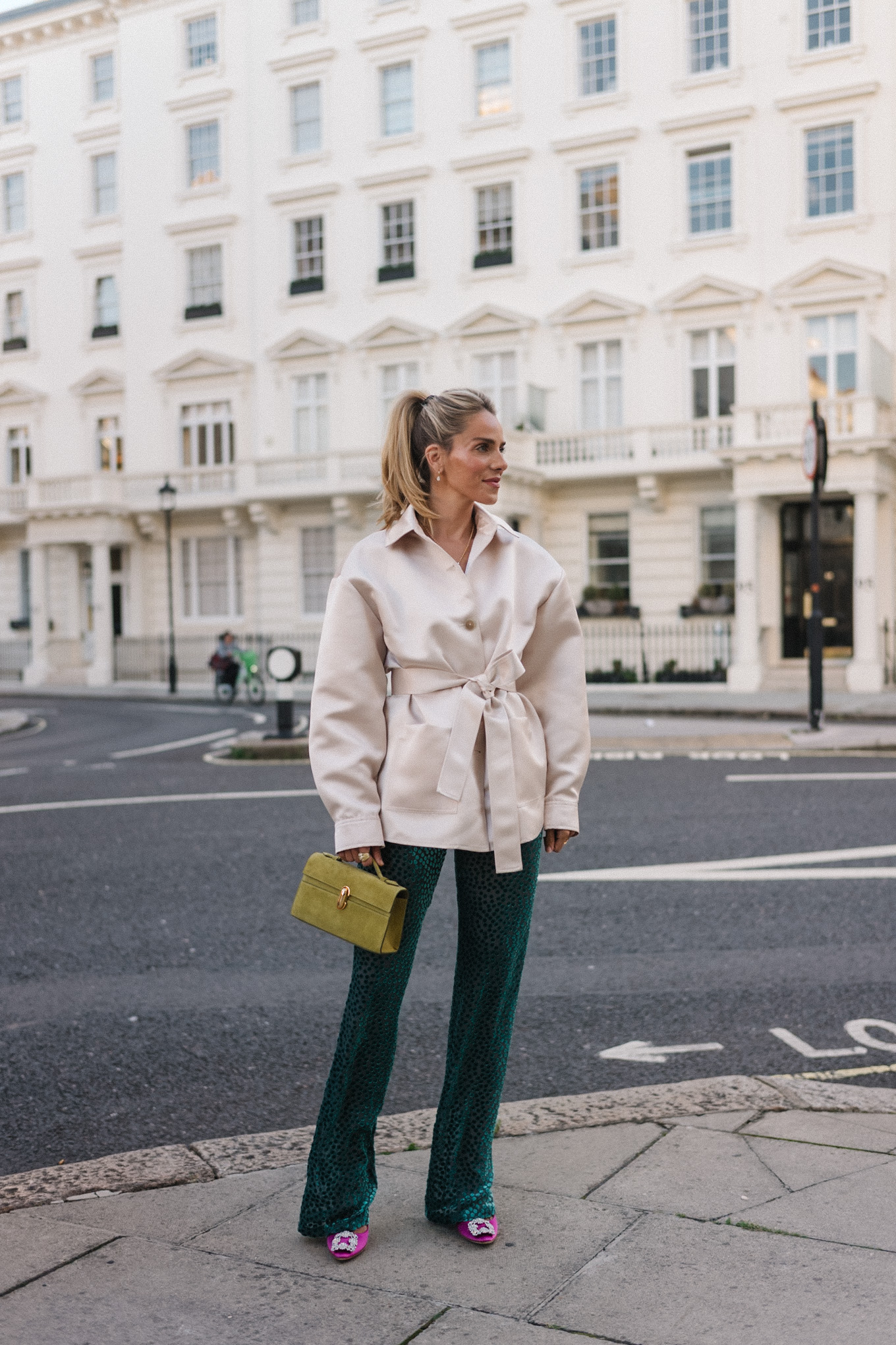 Veste blazer en satin, pantalon en velours vert, escarpins roses, sac à main chartreuse