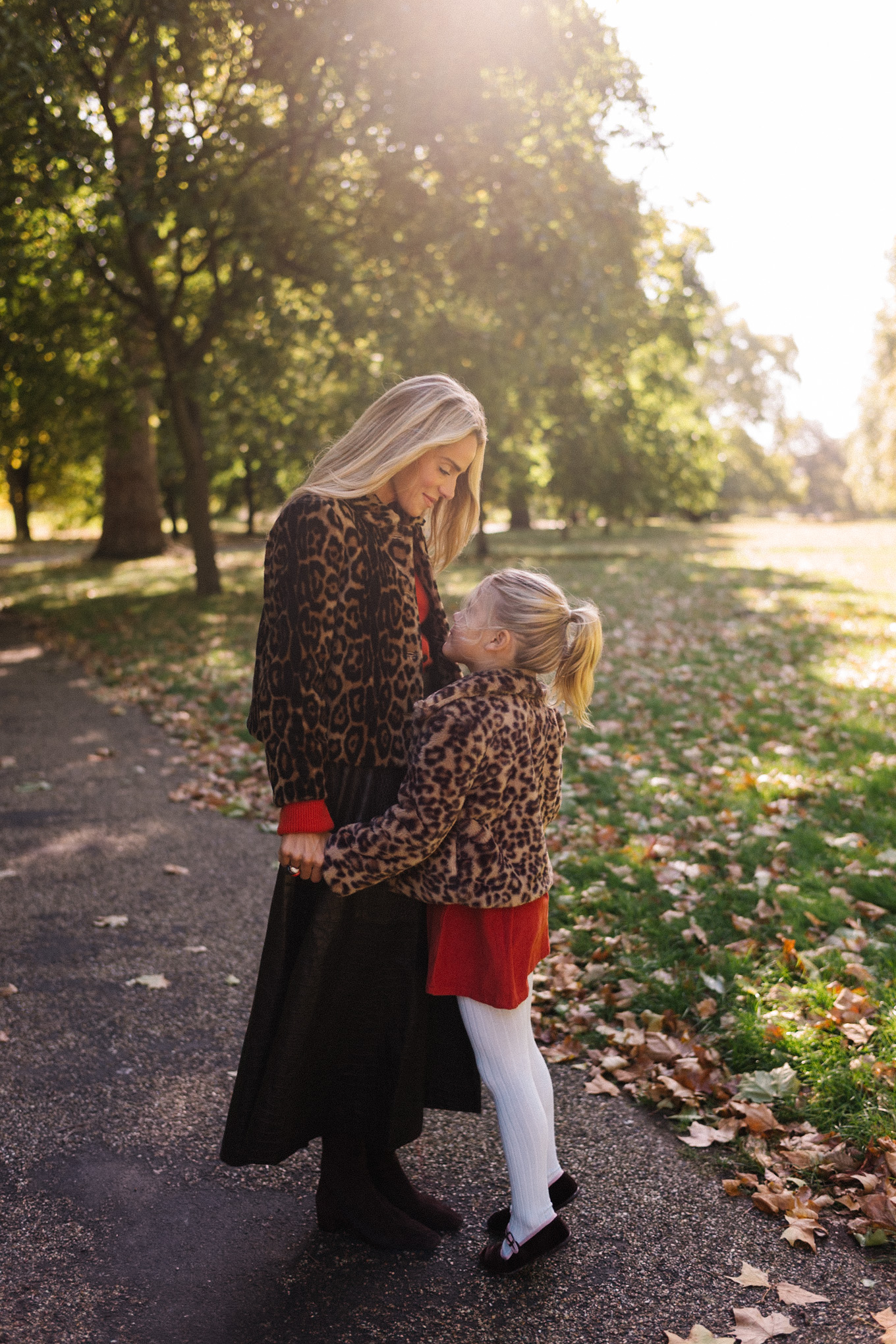 Veste en peau lainée à imprimé léopard, jupe longue marron, cardigan rouge-orange, bottes en daim