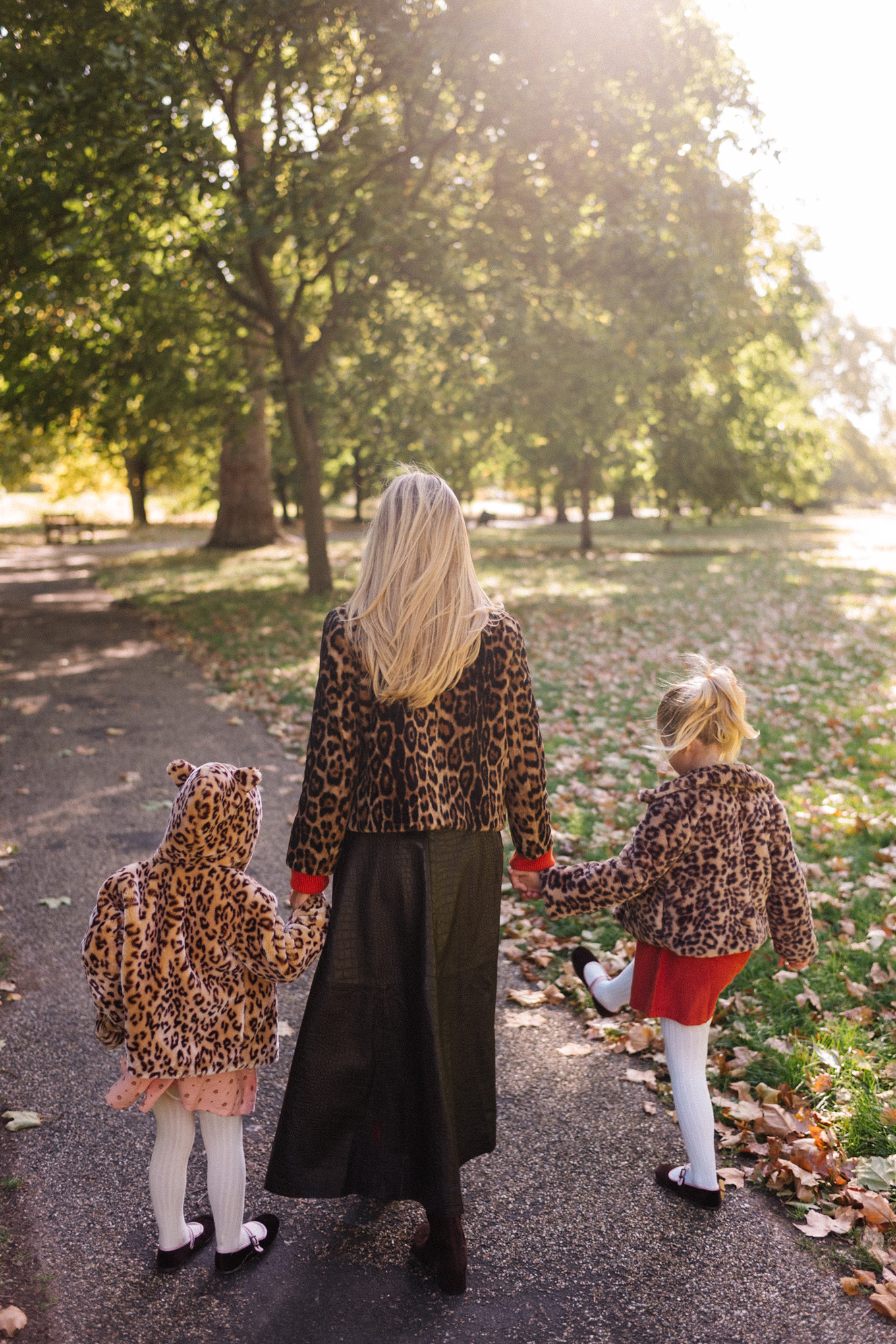 Veste en peau lainée à imprimé léopard, jupe longue marron, cardigan rouge-orange, bottes en daim