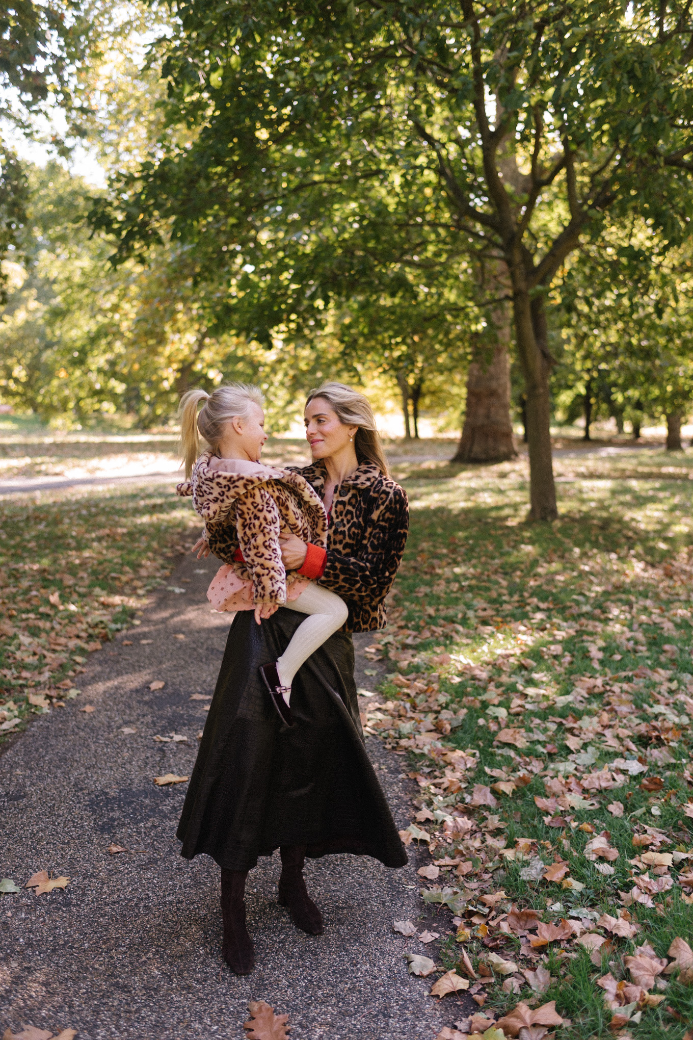 Veste en peau lainée à imprimé léopard, jupe longue marron, cardigan rouge-orange, bottes en daim
