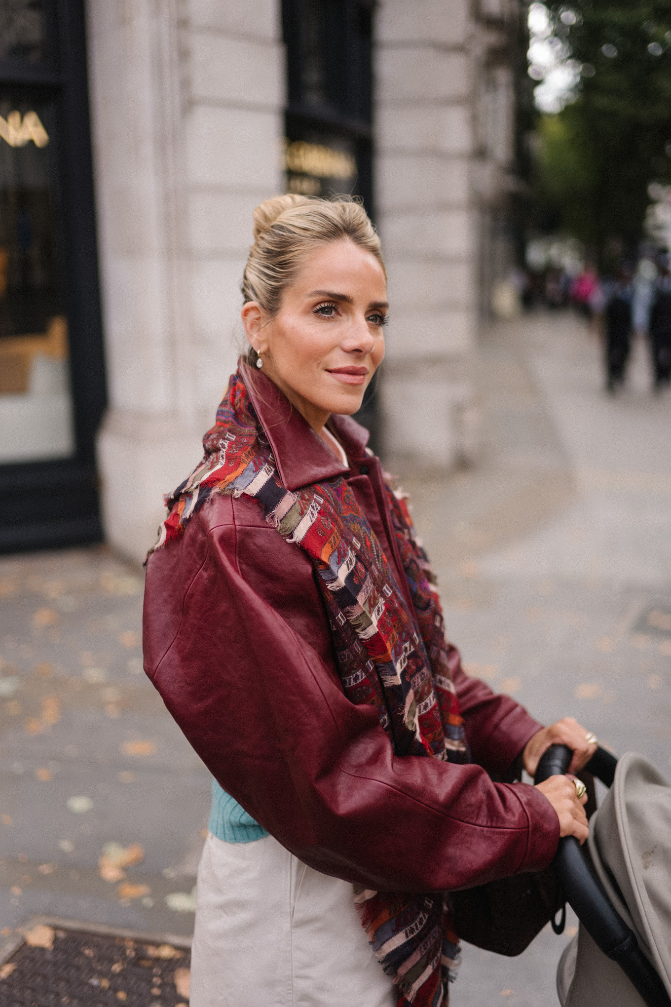 veste en cuir marron, écharpe rayée, pull turquoise, chemise boutonnée blanche, pantalon large crème