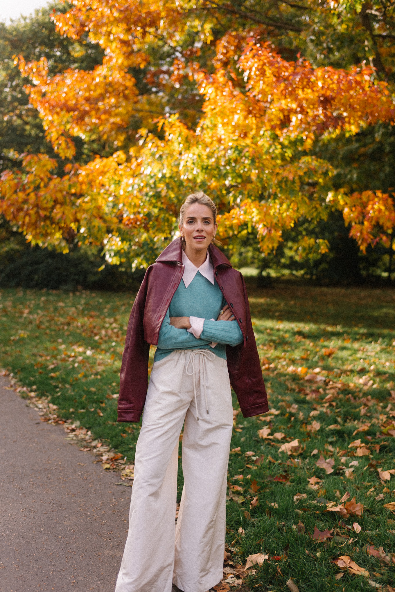 veste en cuir marron, écharpe rayée, pull turquoise, chemise boutonnée blanche, pantalon large crème