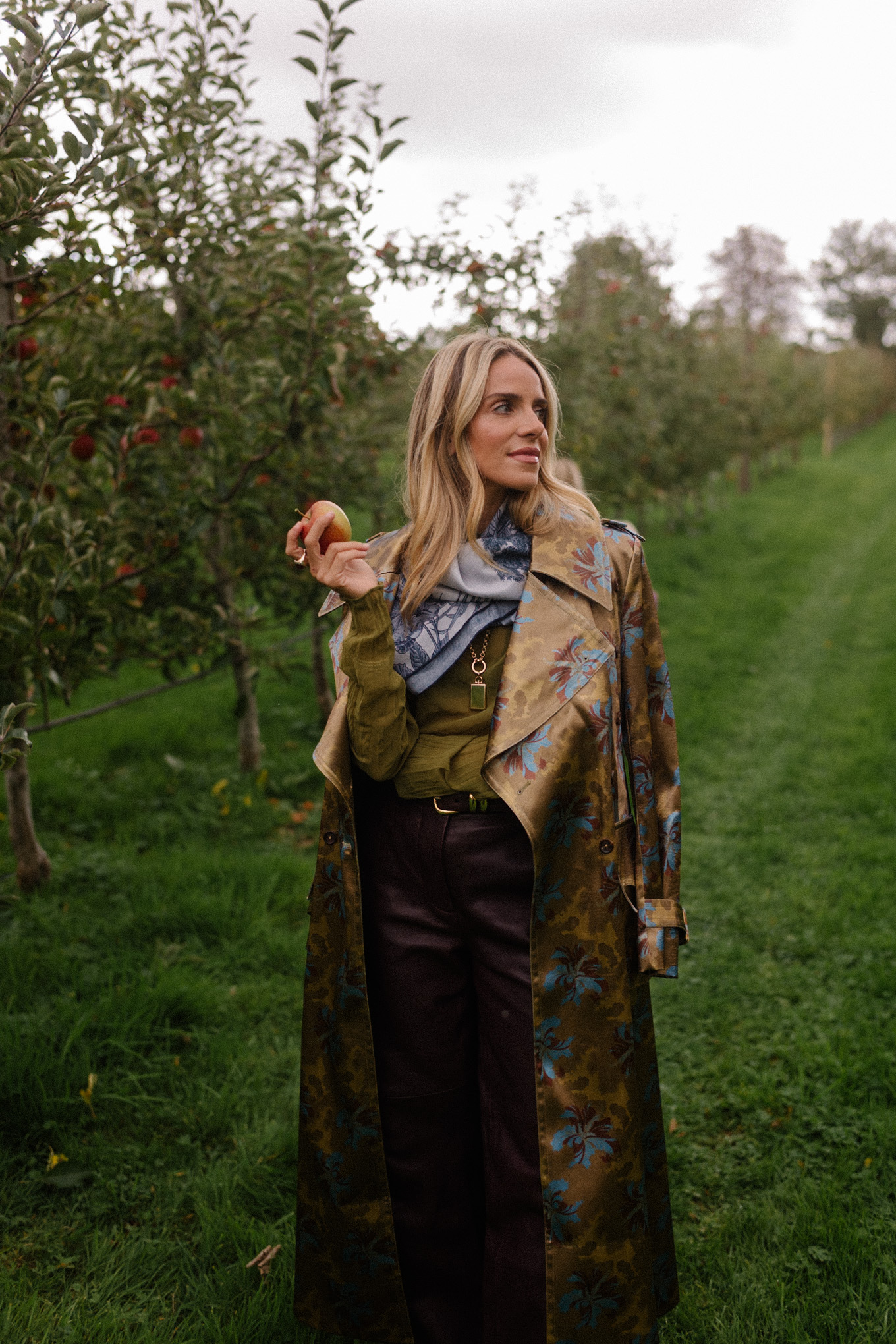 Blouse transparente verte, pantalon en cuir marron, écharpe bleue, trench jacquard