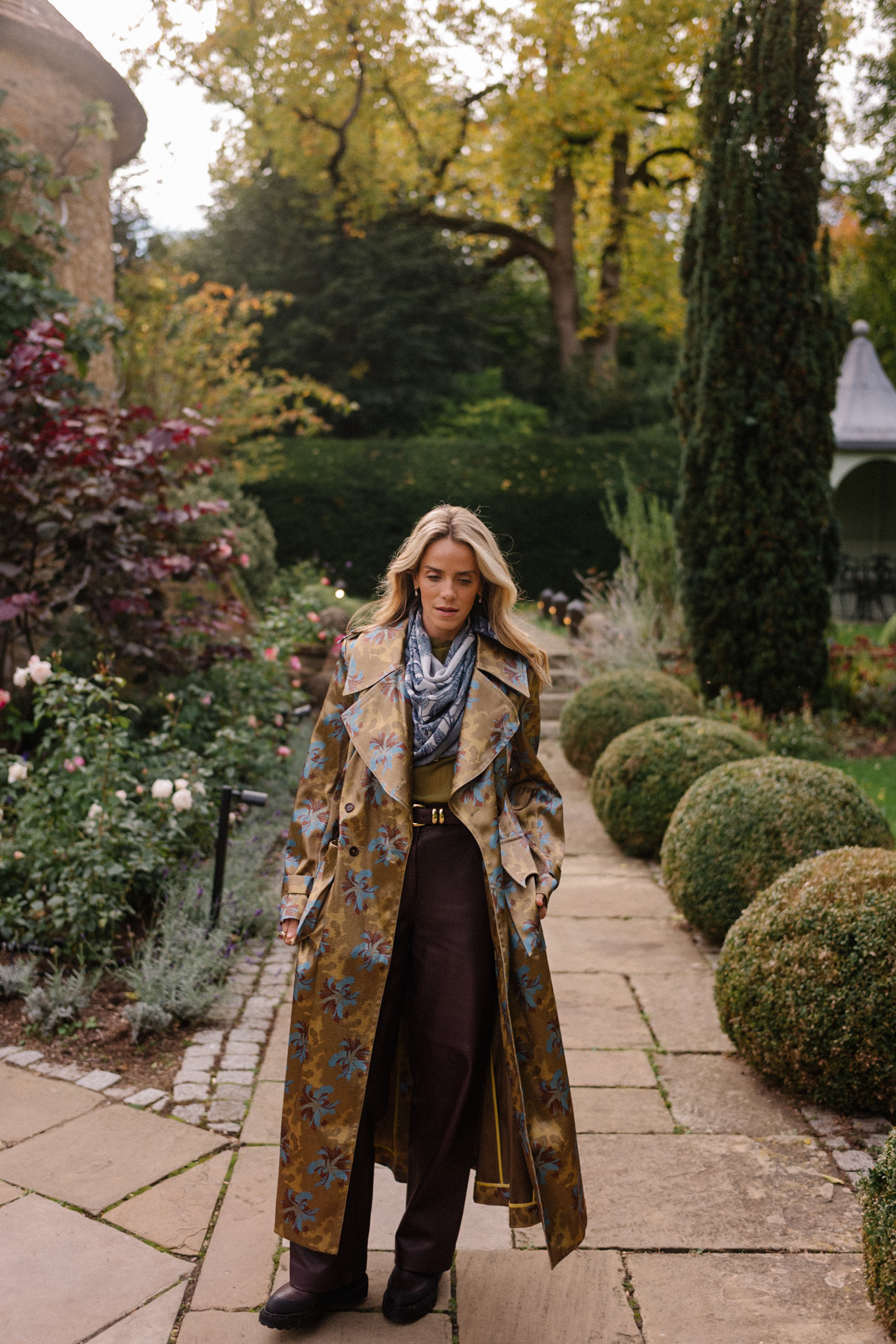 Blouse transparente verte, pantalon en cuir marron, écharpe bleue, trench jacquard