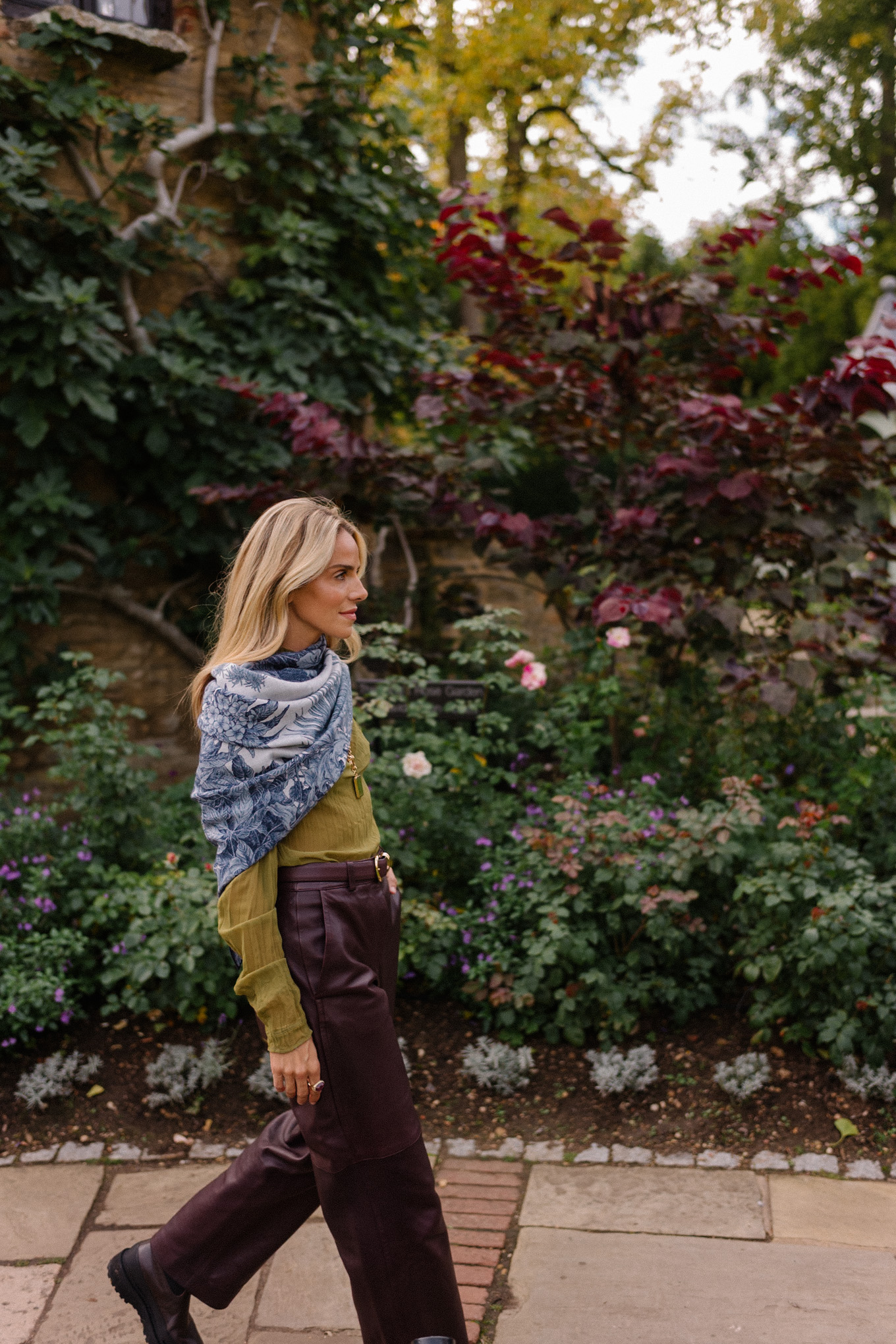 Blouse transparente verte, pantalon en cuir marron, écharpe bleue, trench jacquard