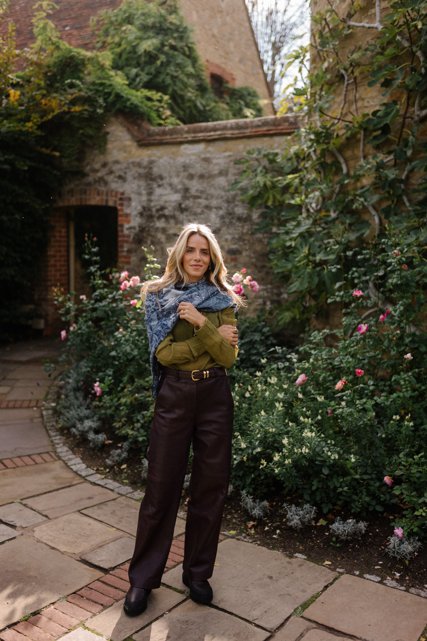 Blouse transparente verte, pantalon en cuir marron, écharpe bleue, trench jacquard