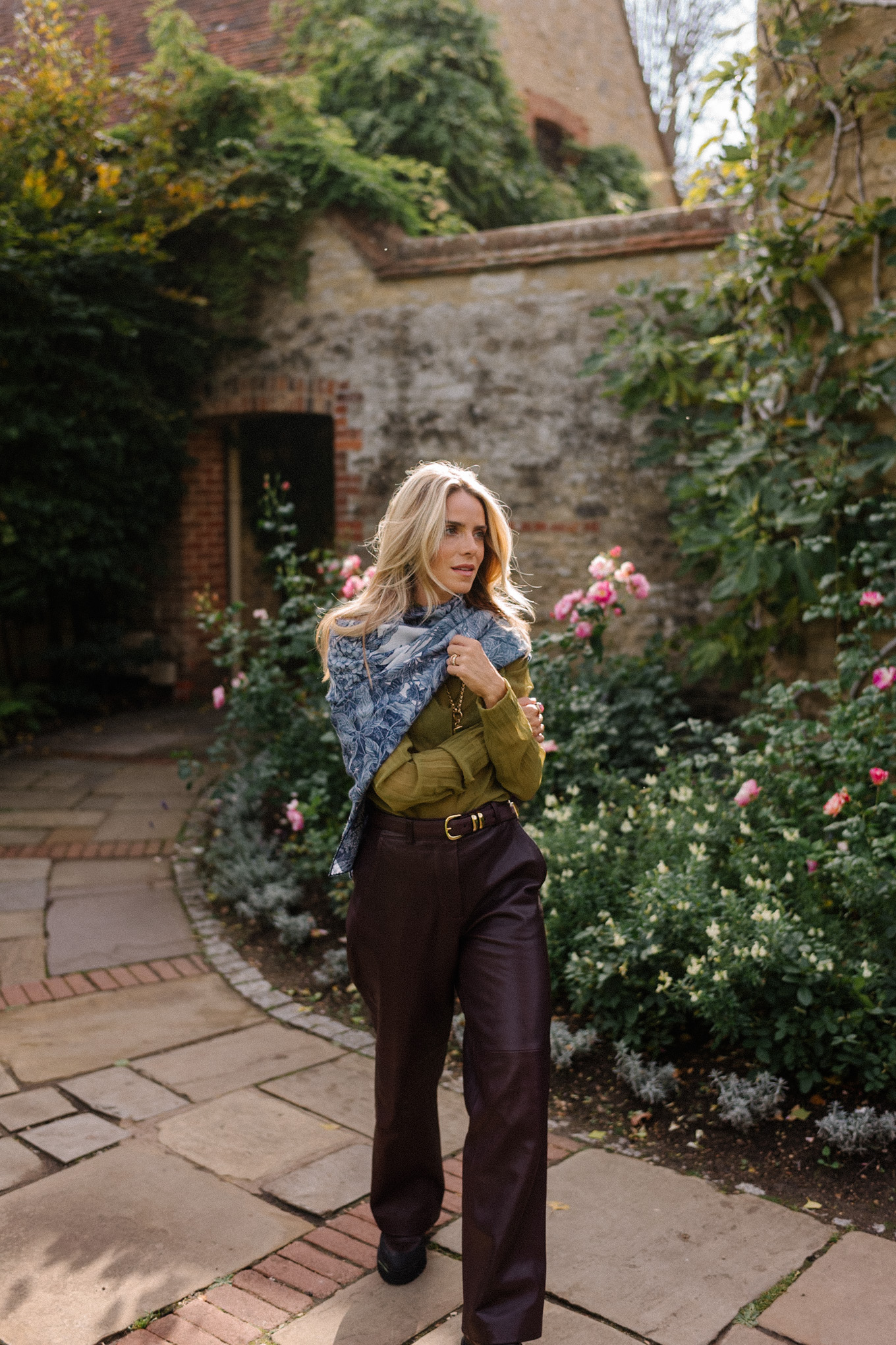 Blouse transparente verte, pantalon en cuir marron, écharpe bleue, trench jacquard
