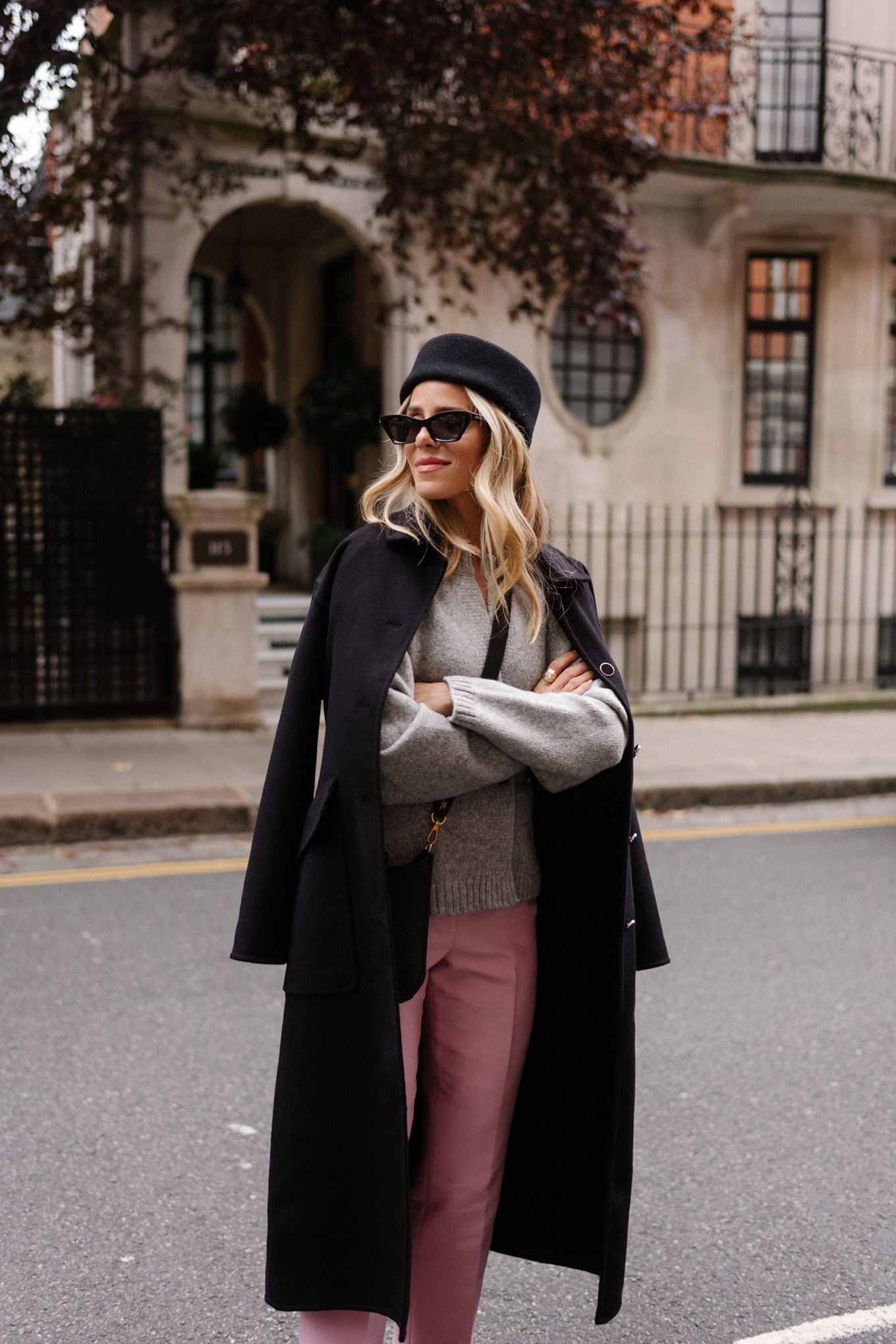 manteau en laine noire, cardigan gris, pantalon en satin rose, chapeau casemate en laine noire