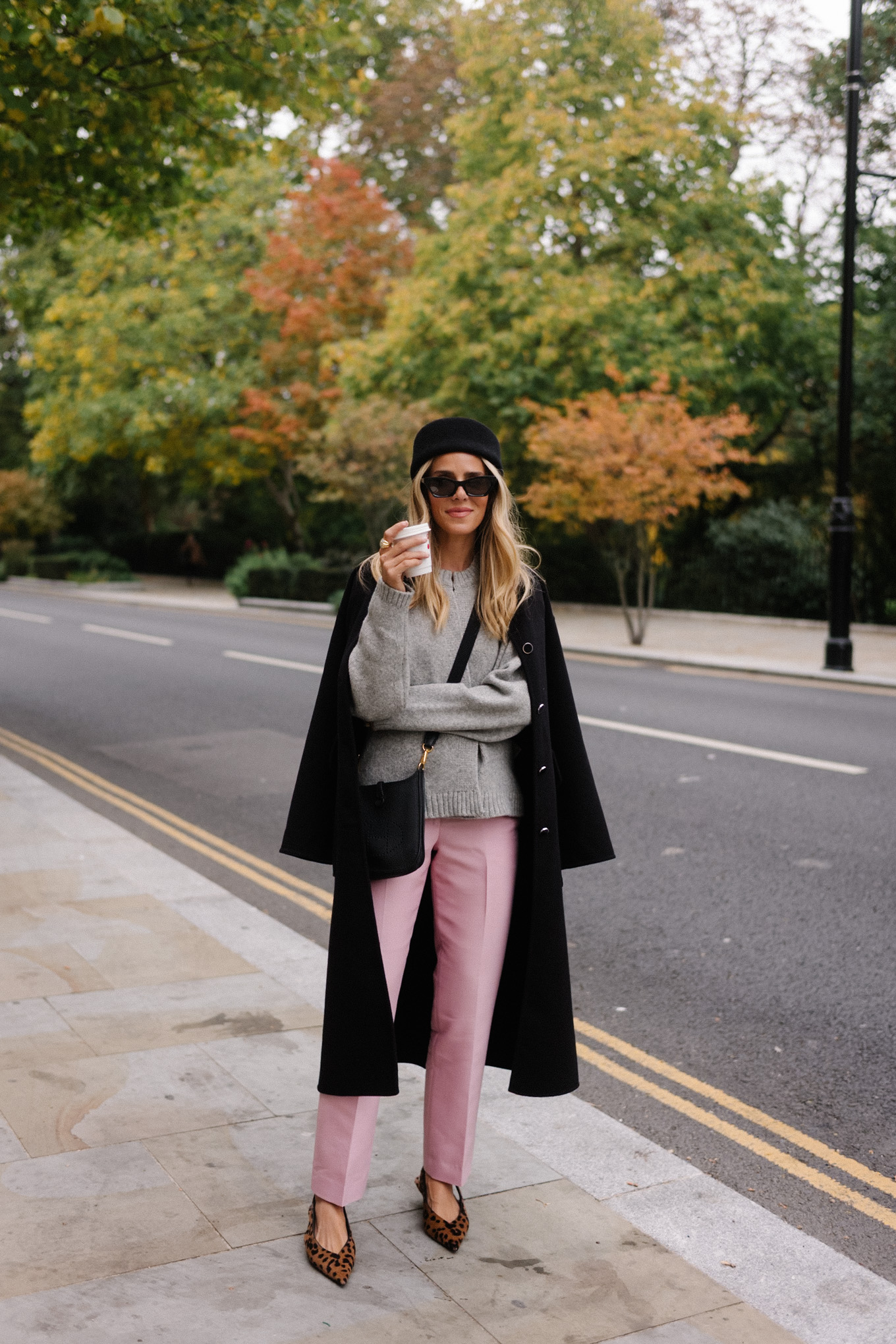 manteau en laine noire, cardigan gris, pantalon en satin rose, chapeau casemate en laine noire