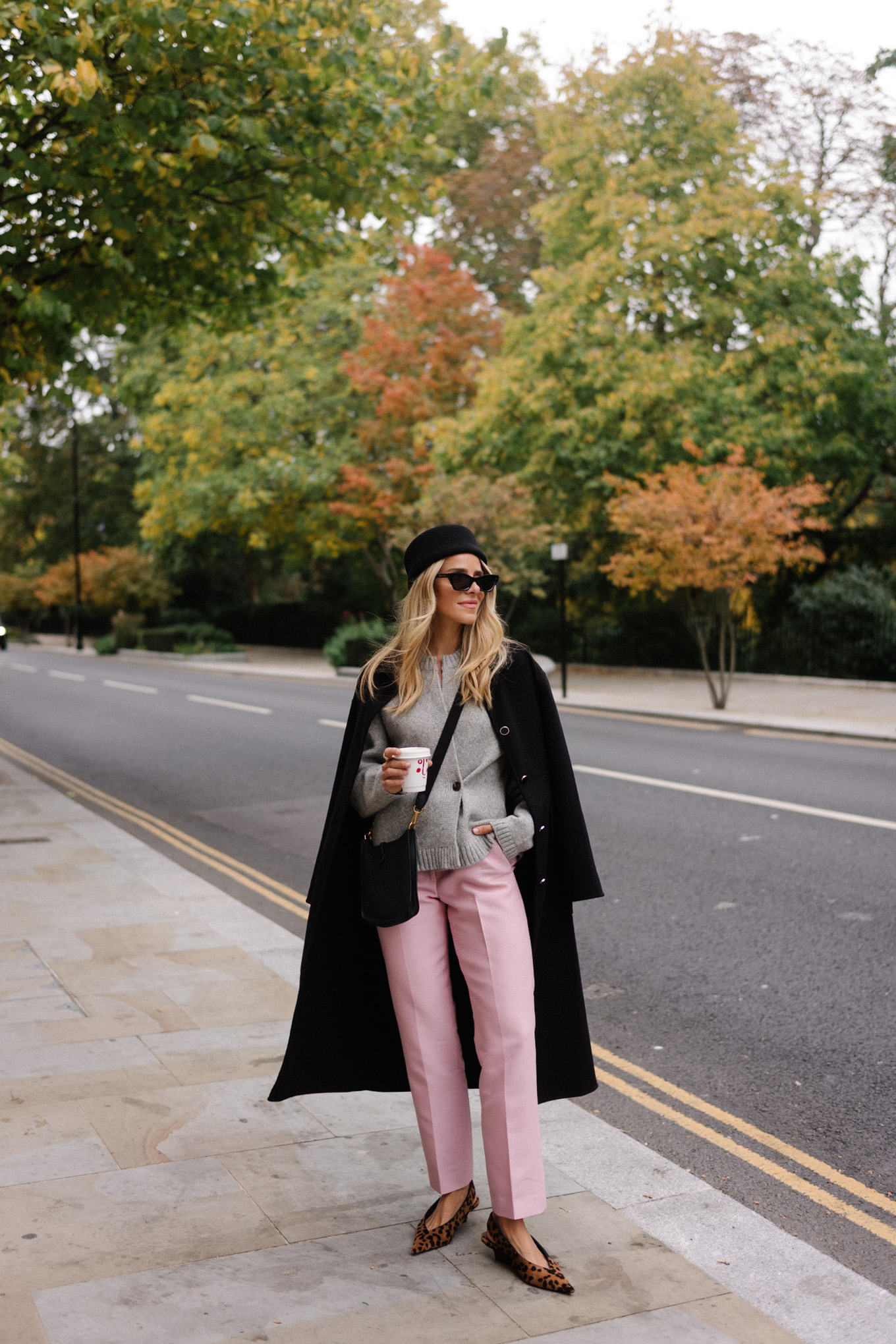 manteau en laine noire, cardigan gris, pantalon en satin rose, chapeau casemate en laine noire