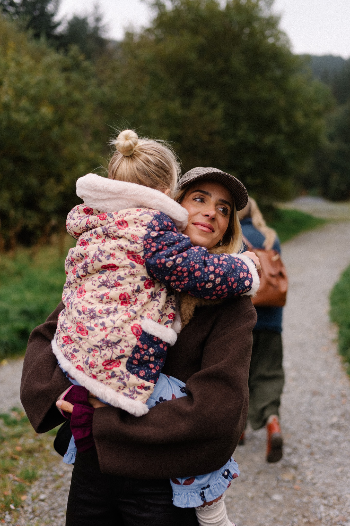 manteau en laine marron, écharpe avec col en fausse fourrure, pantalon en cuir noir, cardigan en cachemire