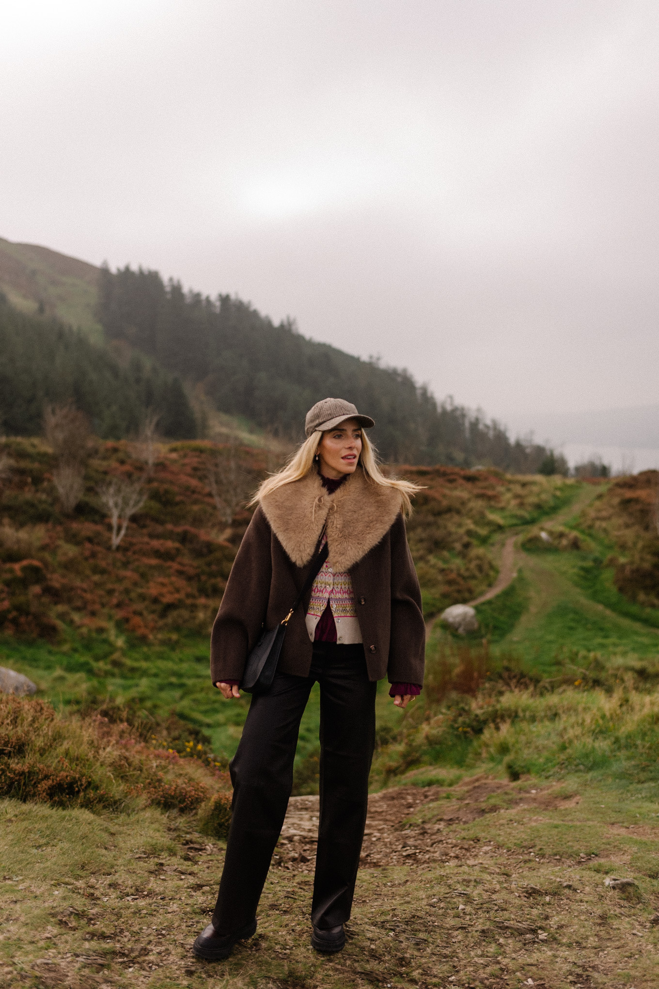 manteau en laine marron, écharpe avec col en fausse fourrure, pantalon en cuir noir, cardigan en cachemire