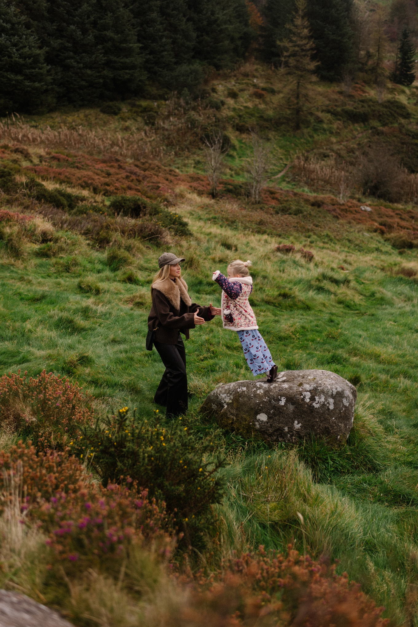 manteau en laine marron, écharpe avec col en fausse fourrure, pantalon en cuir noir, cardigan en cachemire