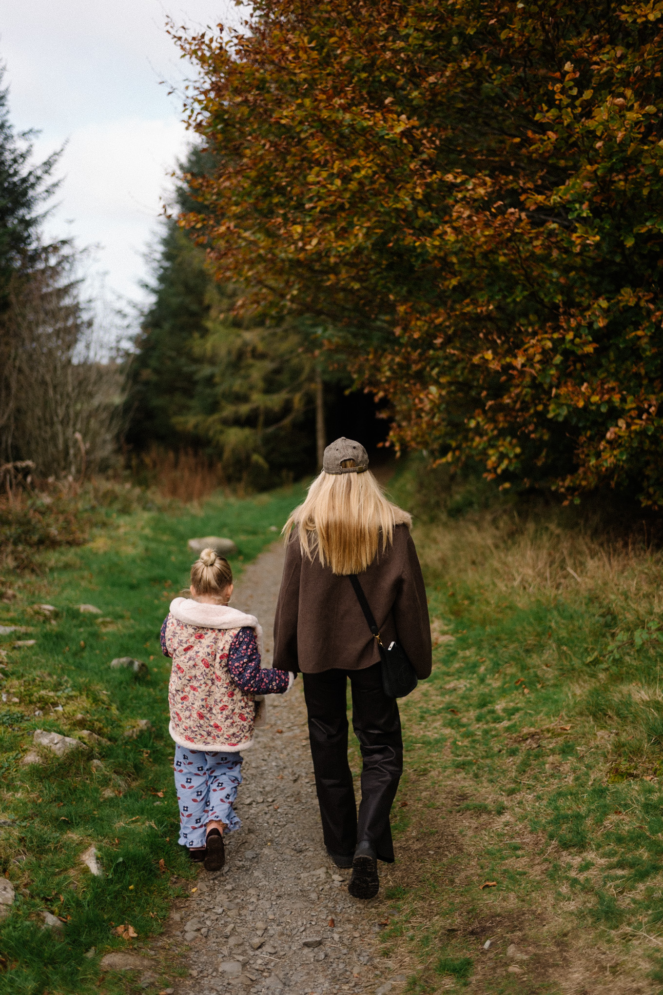 manteau en laine marron, écharpe avec col en fausse fourrure, pantalon en cuir noir, cardigan en cachemire