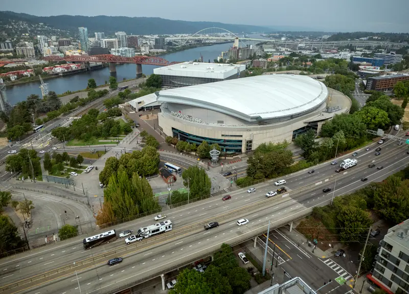 Aerial view of roads and a bridge surrounding a large white-domed building.