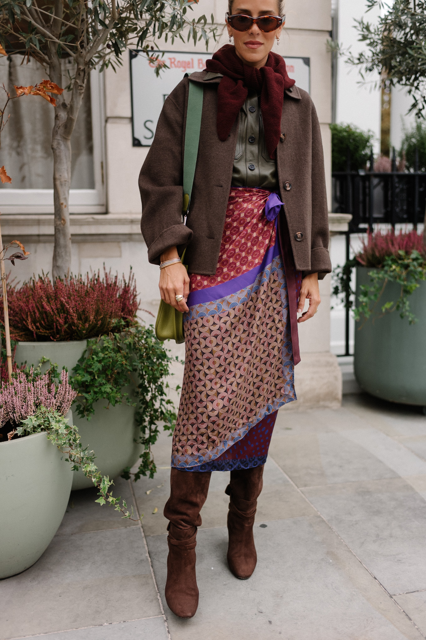 Veste en laine, chemise en cuir à col, jupe portefeuille en soie, bottes en daim