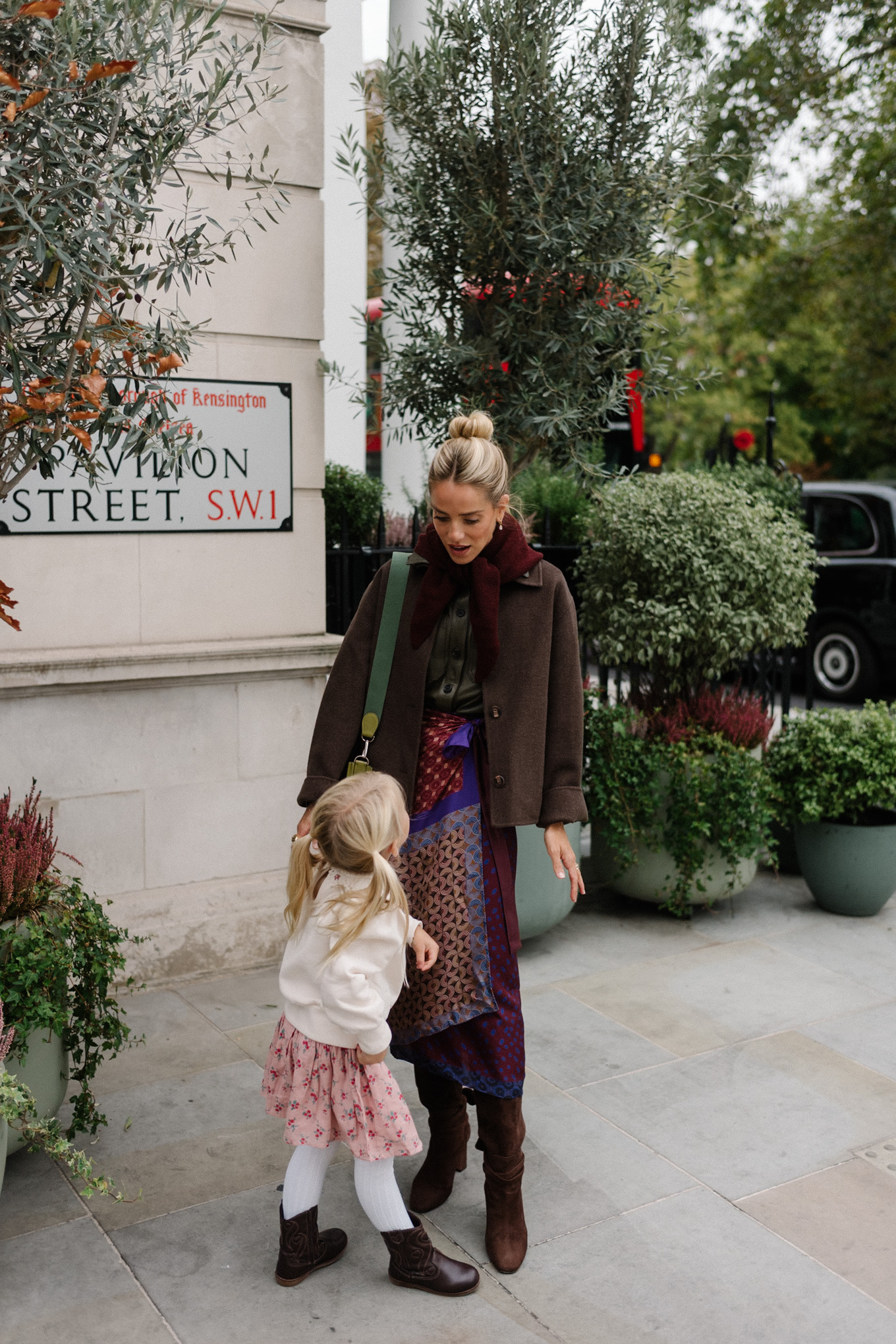Veste en laine, chemise en cuir à col, jupe portefeuille en soie, bottes en daim