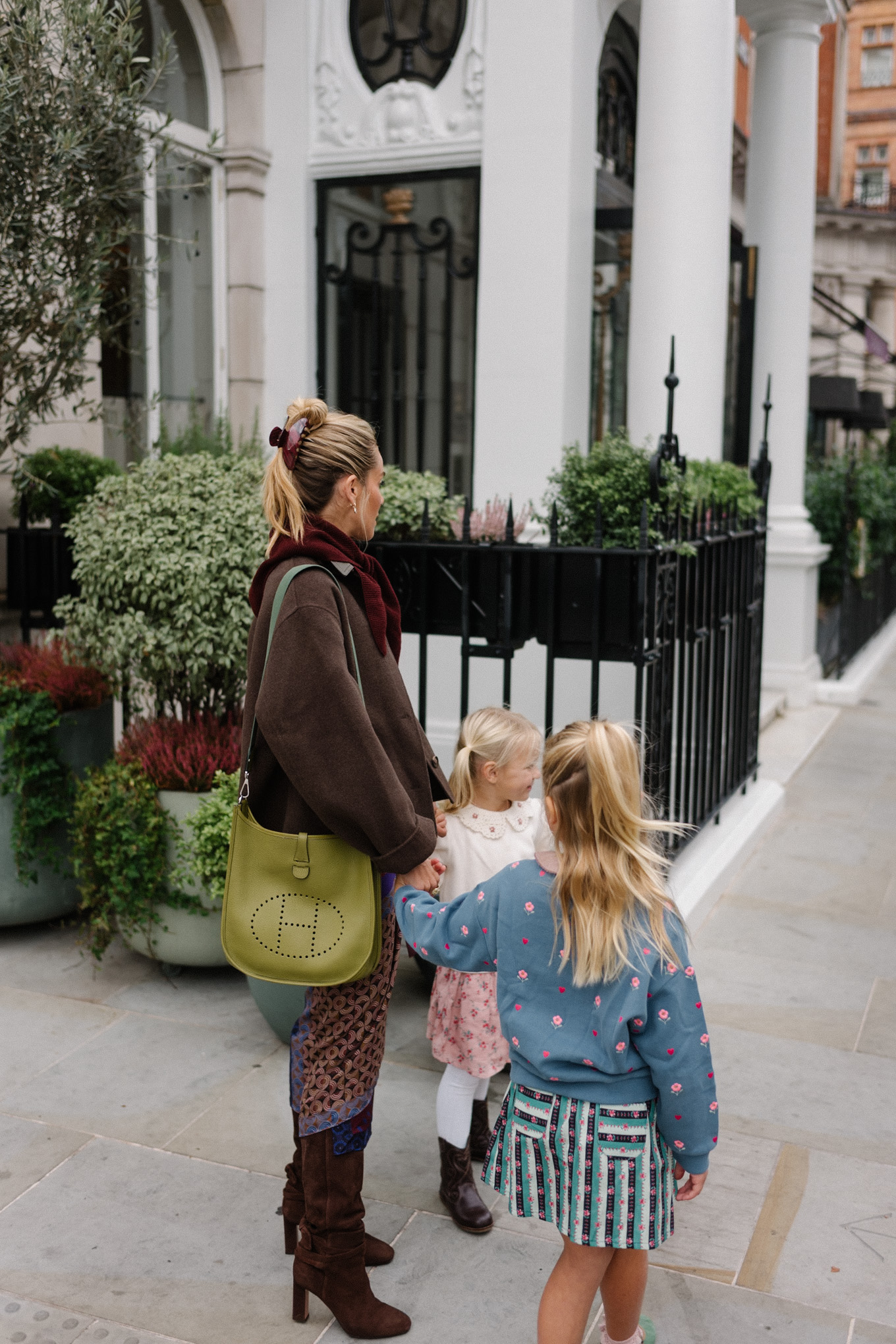 Veste en laine, chemise en cuir à col, jupe portefeuille en soie, bottes en daim