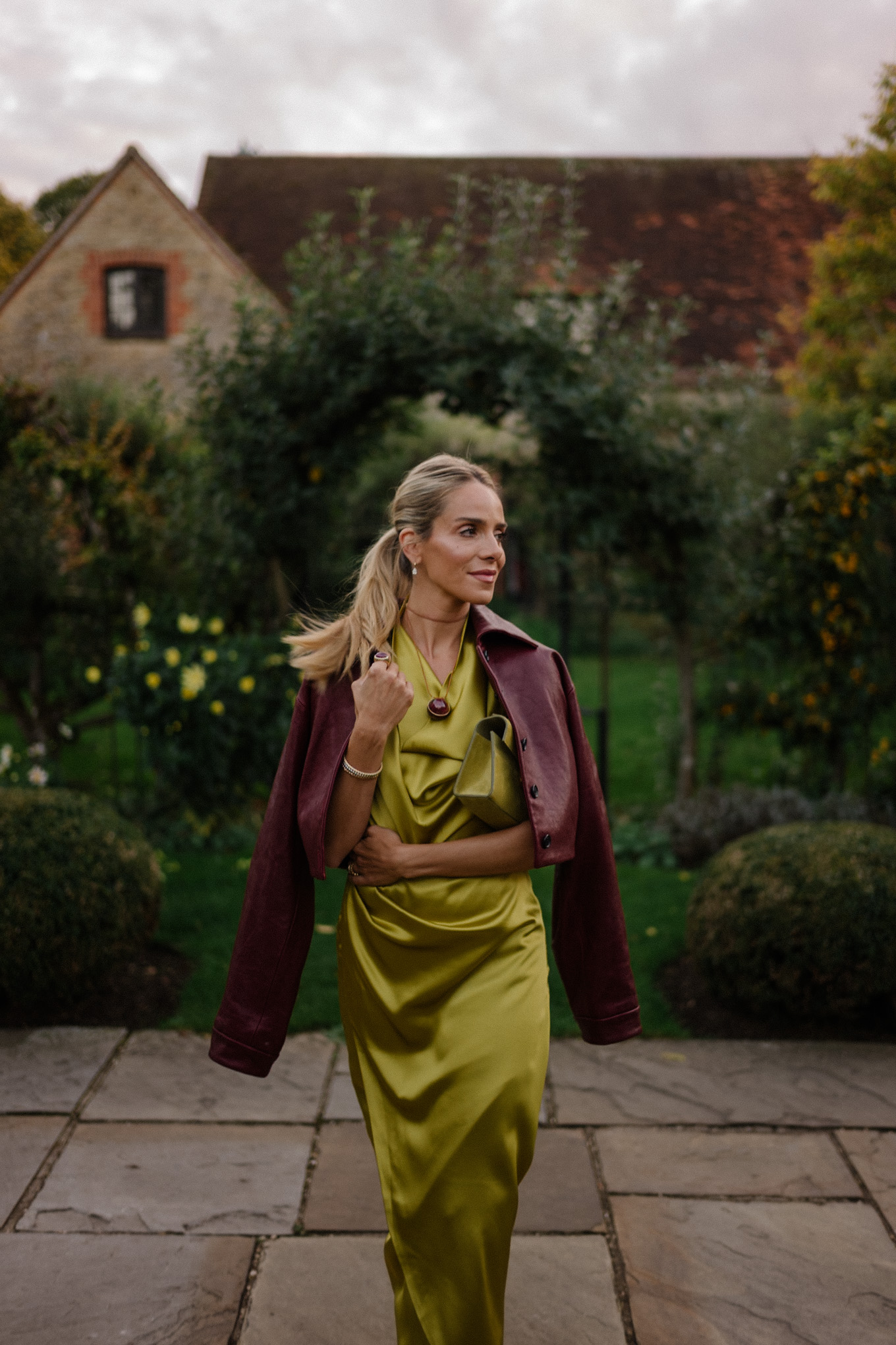 Robe en satin chartreuse, veste en cuir marron, bottes en daim marron