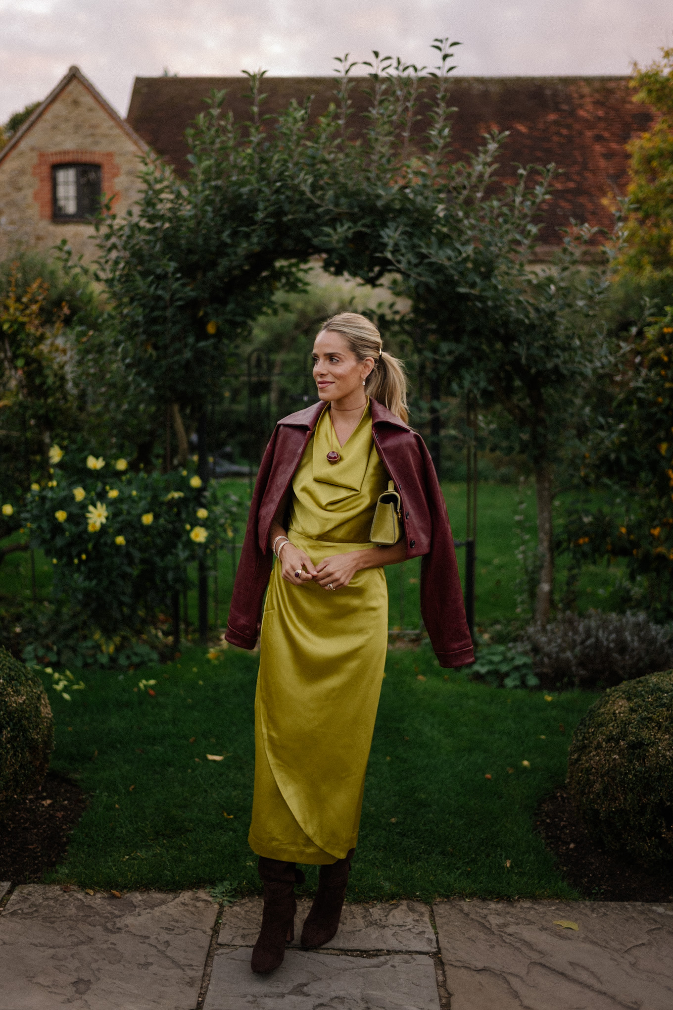 Robe en satin chartreuse, veste en cuir marron, bottes en daim marron