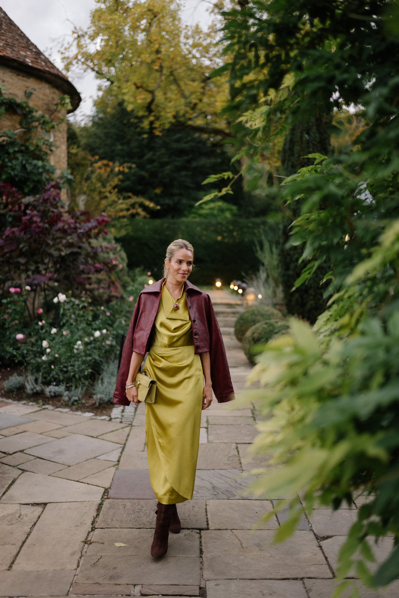 Robe en satin chartreuse, veste en cuir marron, bottes en daim marron