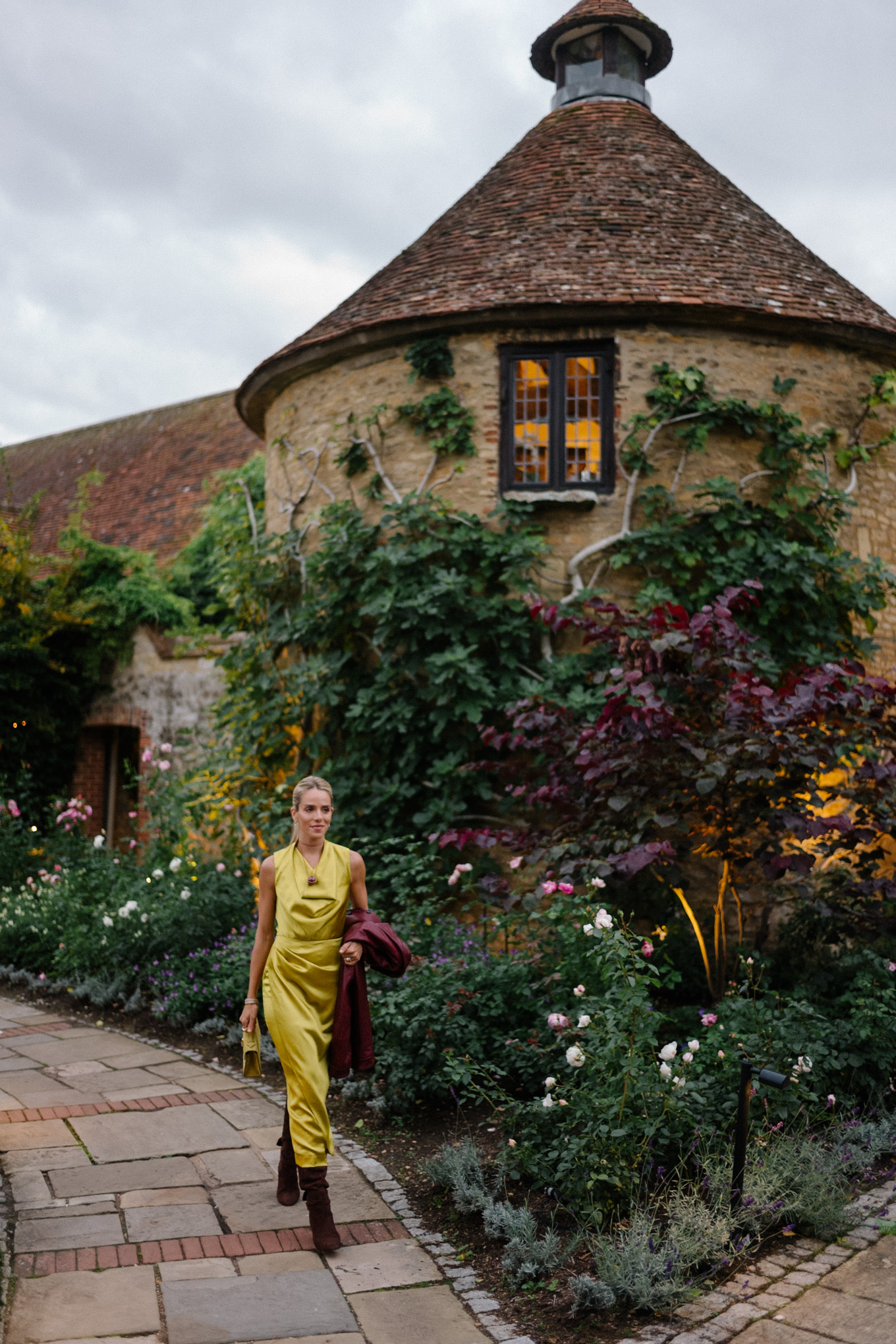 Robe en satin chartreuse, veste en cuir marron, bottes en daim marron
