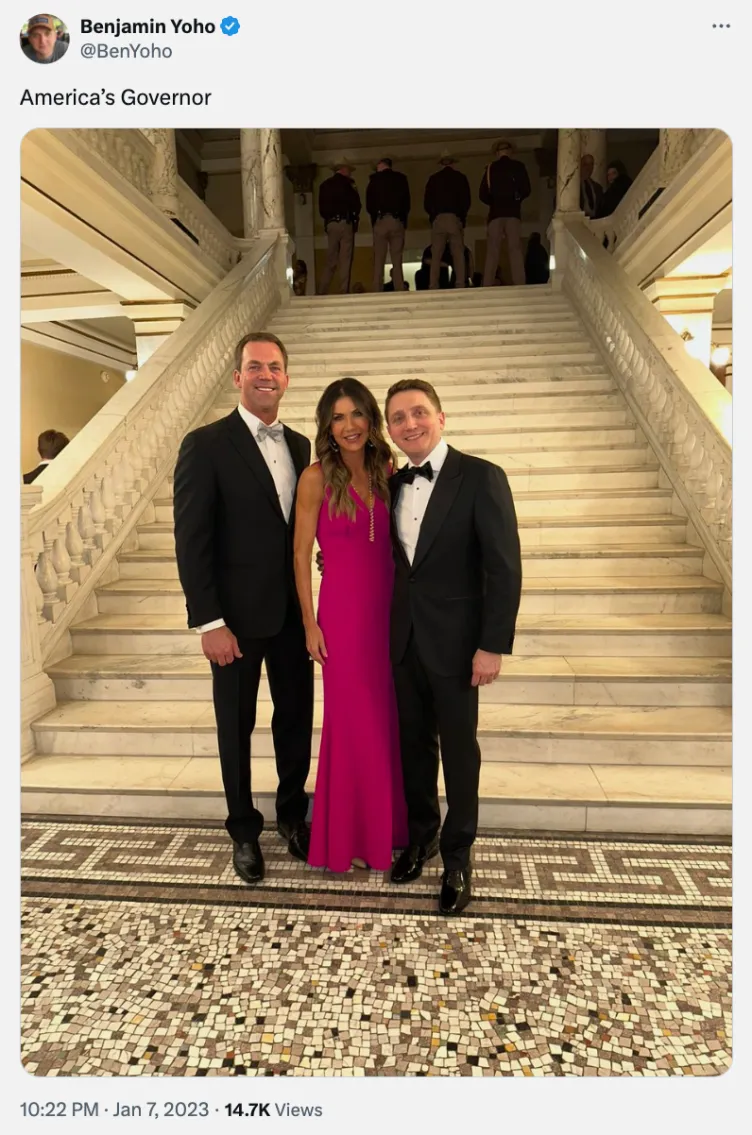 Ein Screenshot eines X-Posts, in dem Benjamin Yoho mit Kristi Noem und ihrem Mann posiert. Sie stehen in formeller Kleidung vor einer breiten Steintreppe.