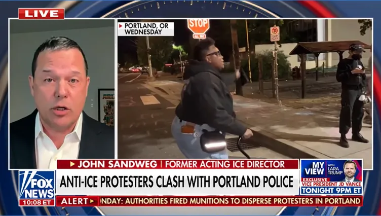 A person on a street with a cane shaking their hand at two people with text that says “Live.”