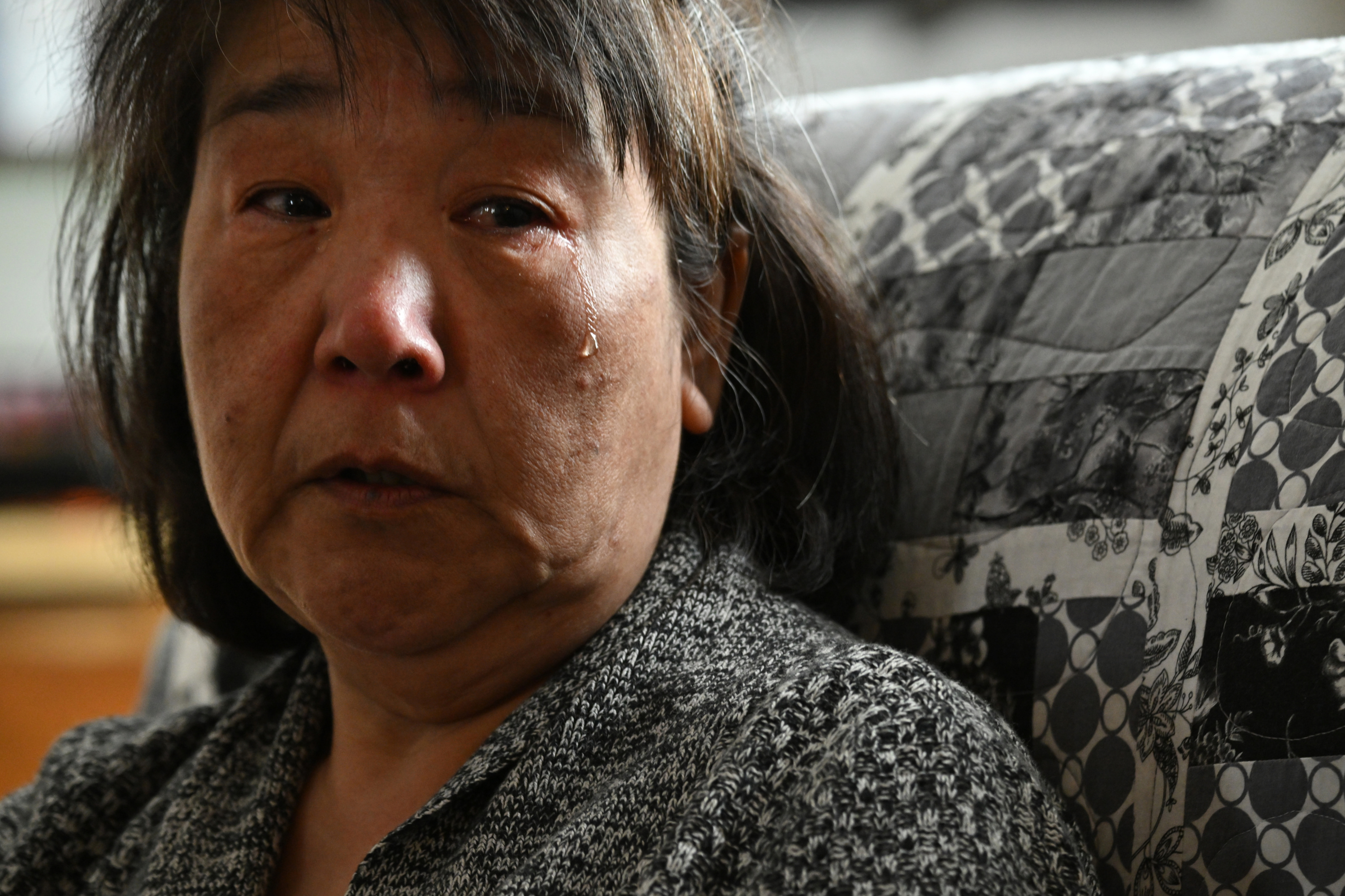 Close-up of a woman’s face. She is frowning and has a single tear running down her cheek.